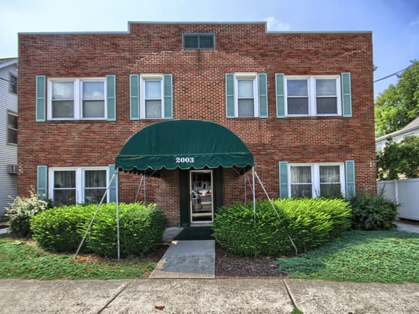 Brick apartment building at 2003 Market St. with a green entry awning