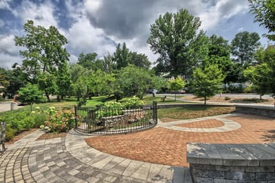 A brick-paved park plaza with gardens