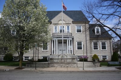 A historic limestone building with a flag